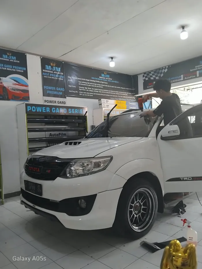 Pemasangan kaca film pada mobil di bengkel DM Kaca Film