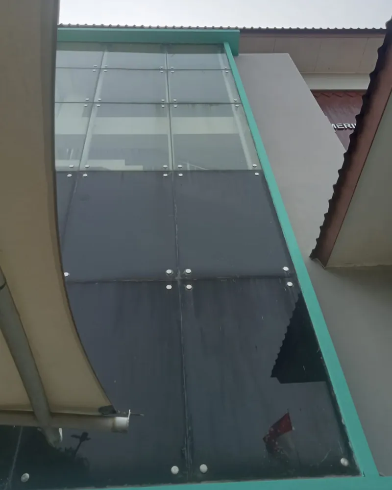 Kaca fasad bangunan dari dekat, sebagian sudah berfilm gelap